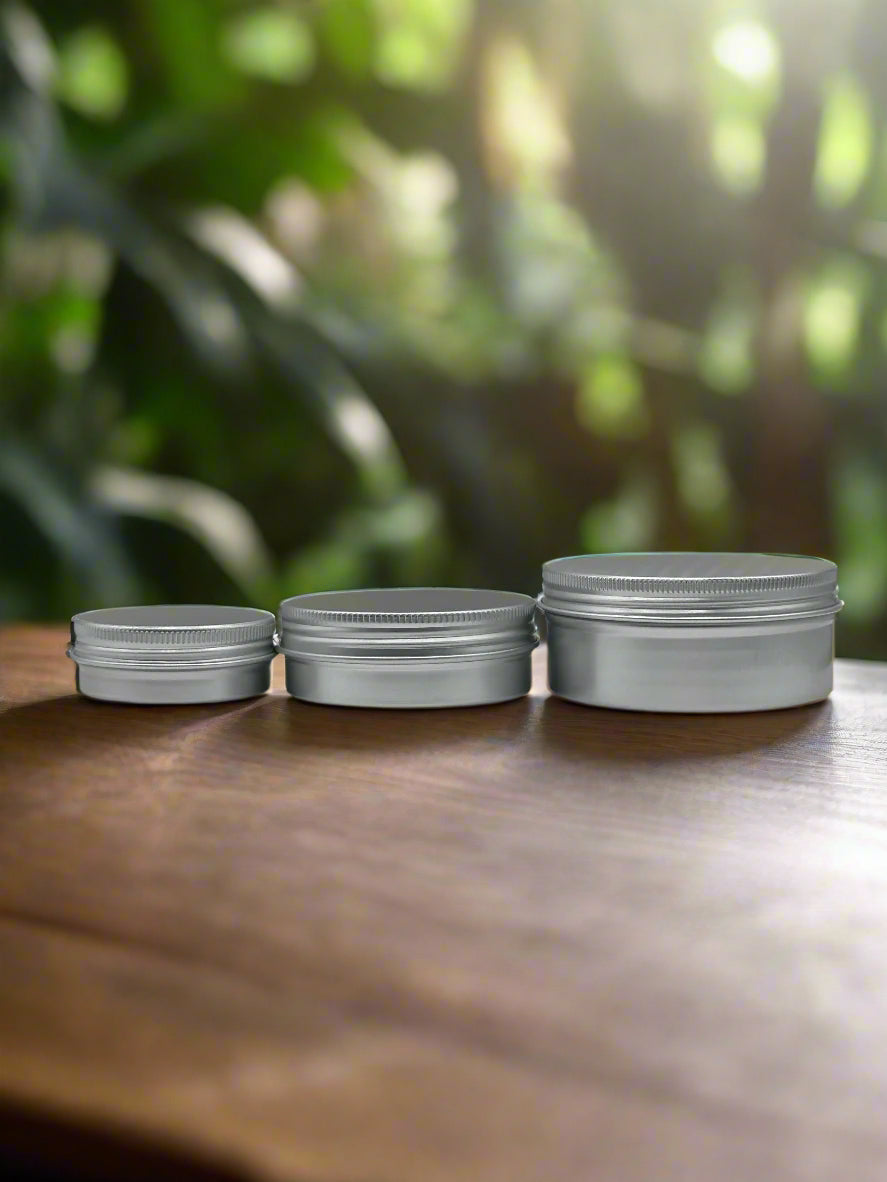 Three silver jars stacked vertically on a white surface with a gray background
